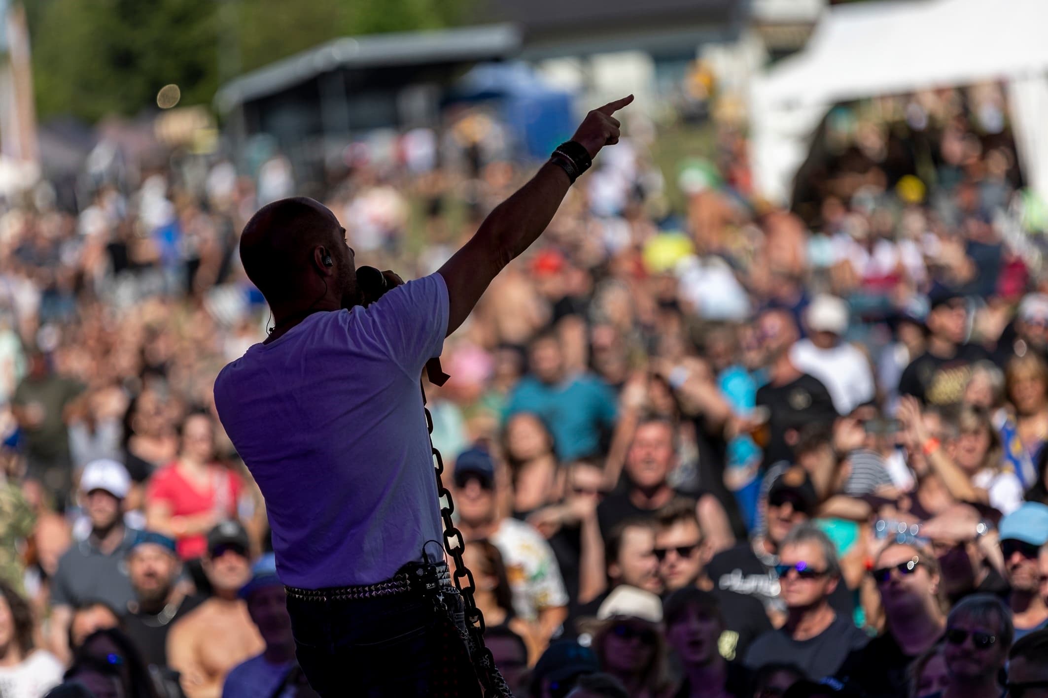 Zpěvák na pódiu ukazuje do zaplněného kotle fanoušků na festivalu Vesuf 2026